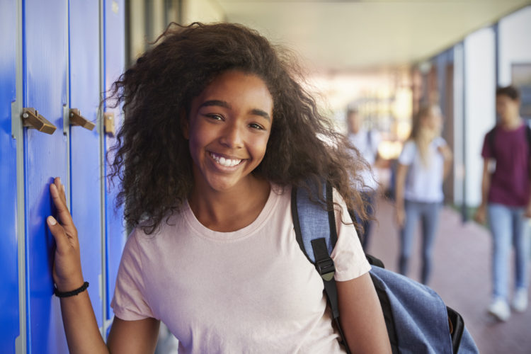 Teenage dark-skinned girl near school lockers